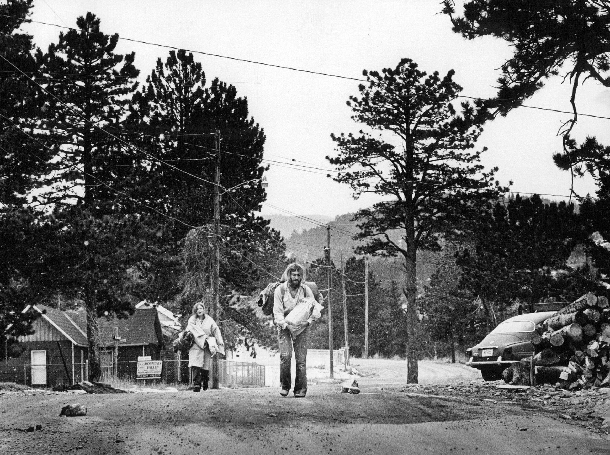 Two residents of Nederland trudge up a hill from a store where they'd just bought supplies. The area is drawing more year-round residents, many of whom are newcomers seeking a low-cost rustic life