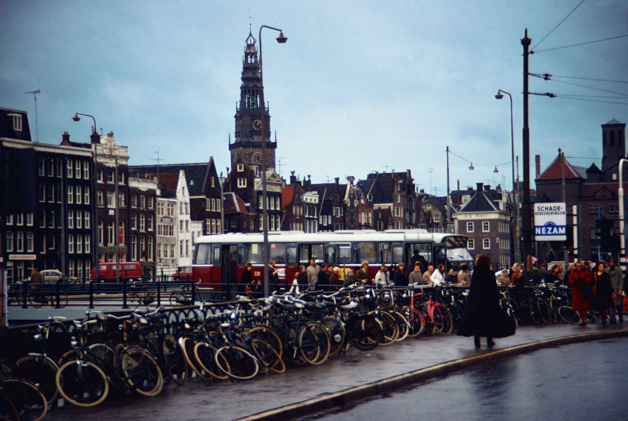 Bicycles on the Damrak in Amsterdam, capital of the Netherlands, with the Oude Kerk in the background - December 1970.