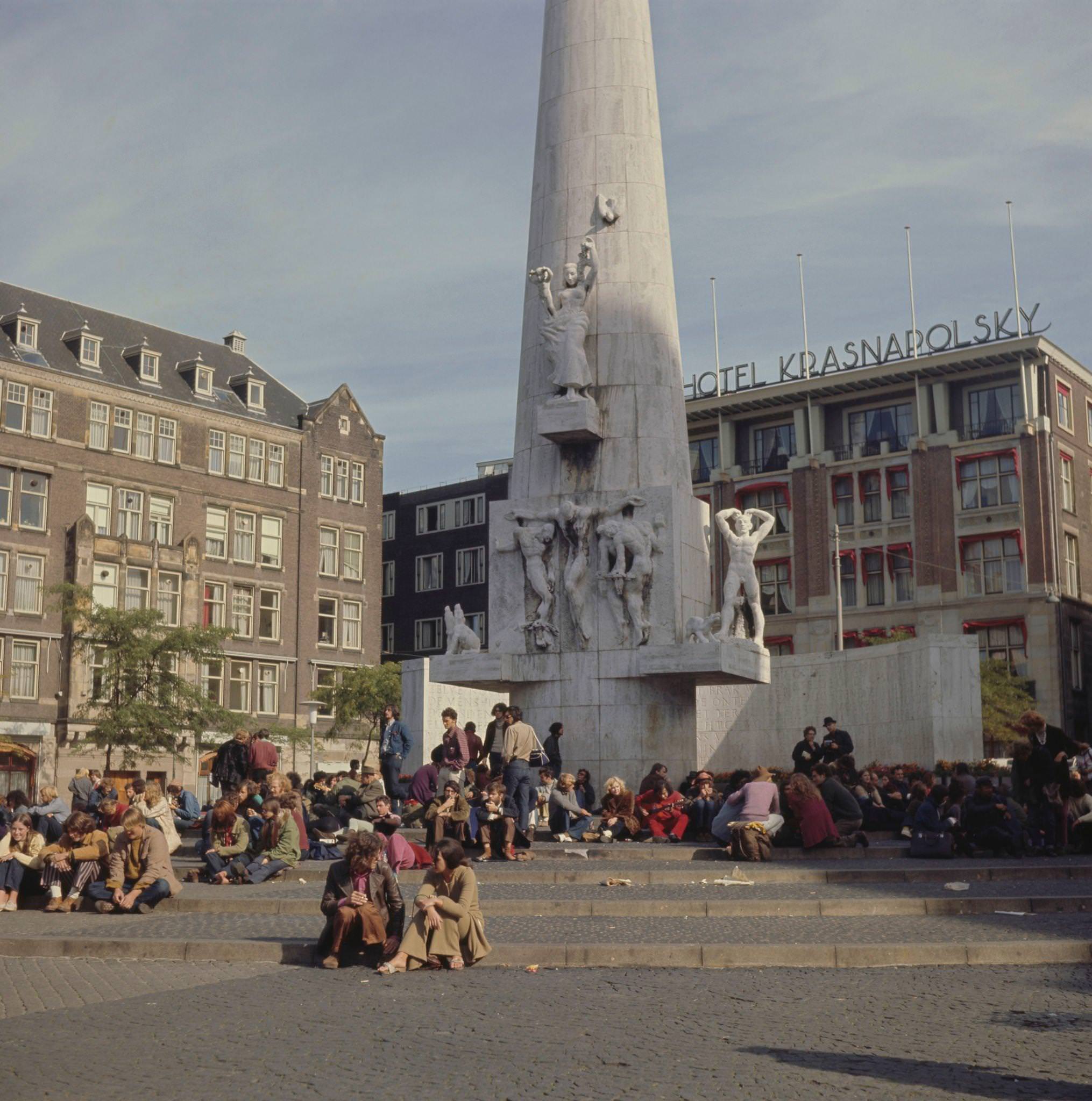 Visitors and residents congregate around the National Monument on Dam Square in the center of Amsterdam, 1970s