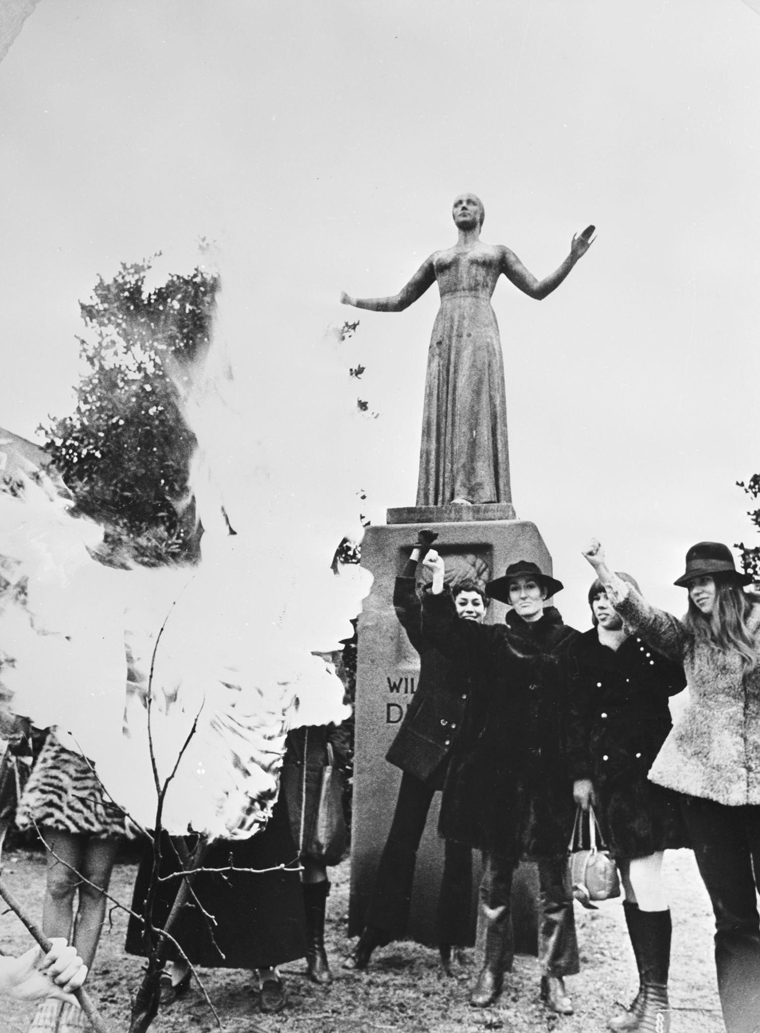 Members of the Dutch branch of the Women's Liberation Movement, the Dolle Mina, burn corsets beneath the statue of Dutch feminist Wilhelmina Drucker (Mad Mina) in Amsterdam, 1970s