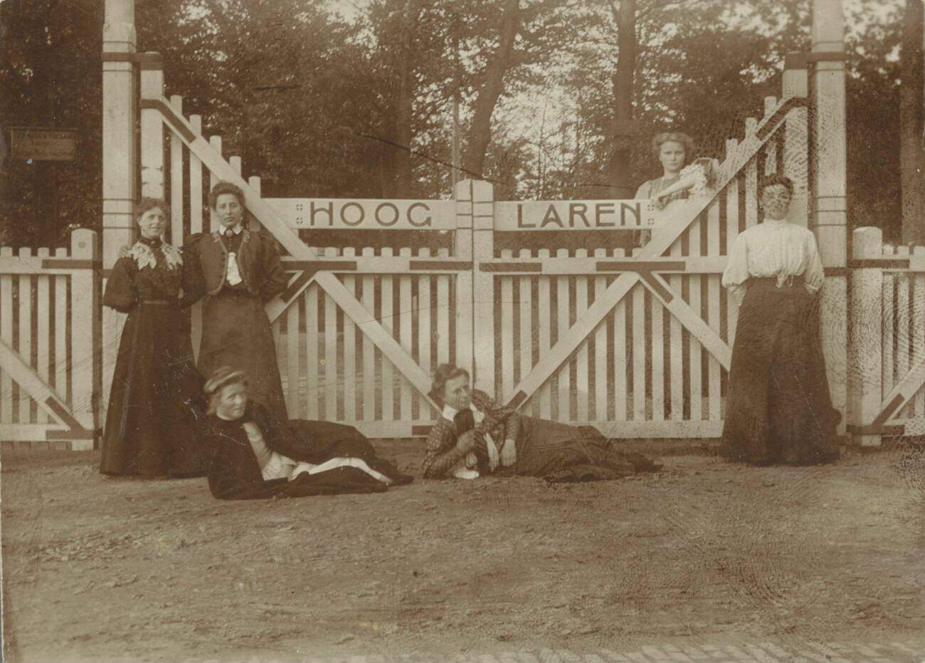 Group portrait of six young ladies in front of the Hooglaren fence, anonymous, Netherlands, 1900