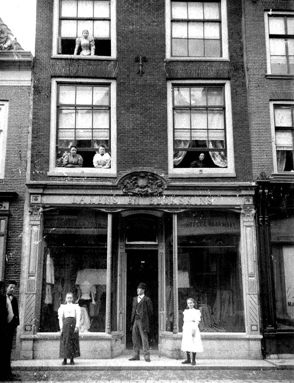 People standing outside of a building on Langestraat in Alkmaar Netherlands, 1900