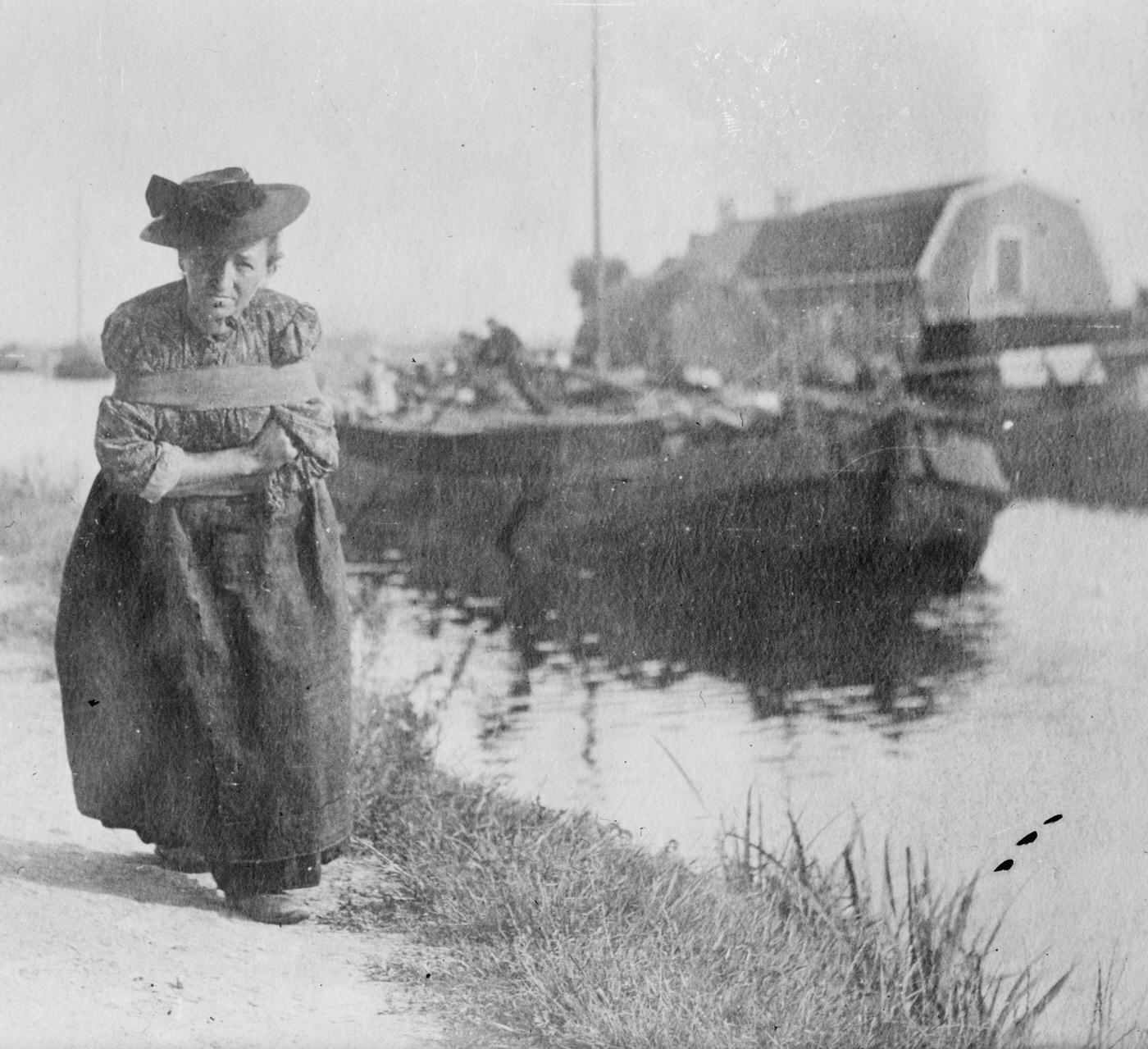 An elderly Dutch woman pulling a barge down a canal, Netherlands, 1900