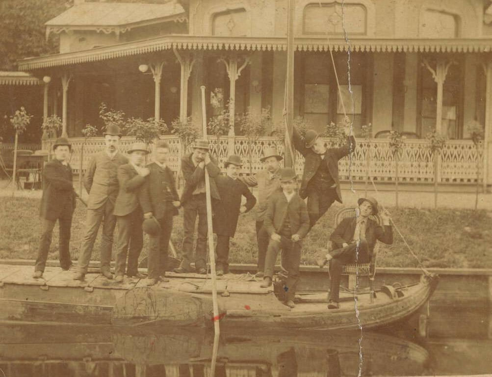 Group portrait of unknown young men on a sloop near a pavilion, 1900s
