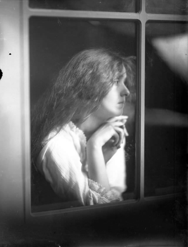 Portrait of a young woman gazing out window, 1910