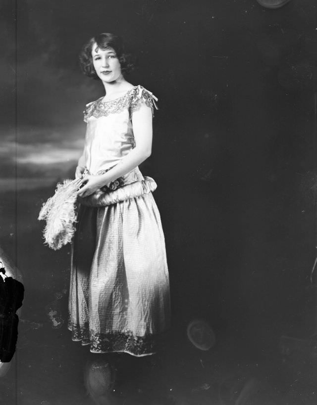 Portrait of a young woman holding a feather fan, 1915