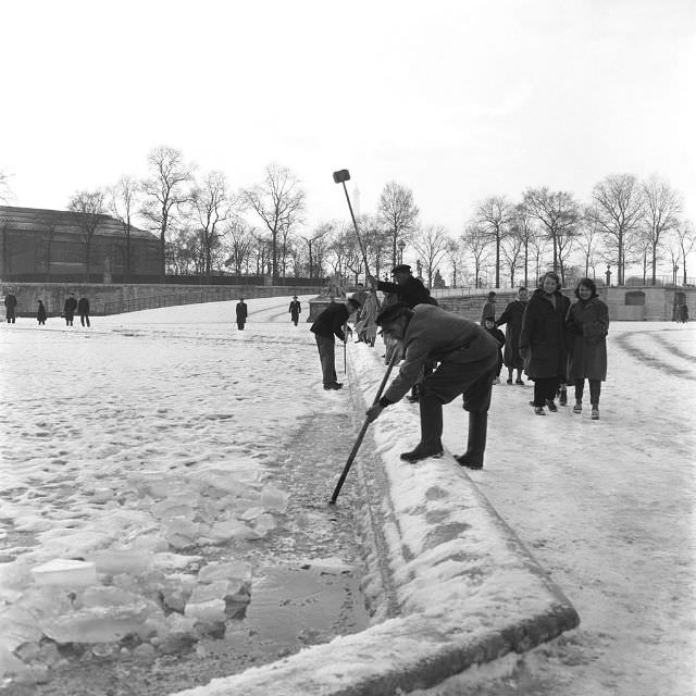 People breaking the ice to save the fish at the Tuileries Garden, 1956.