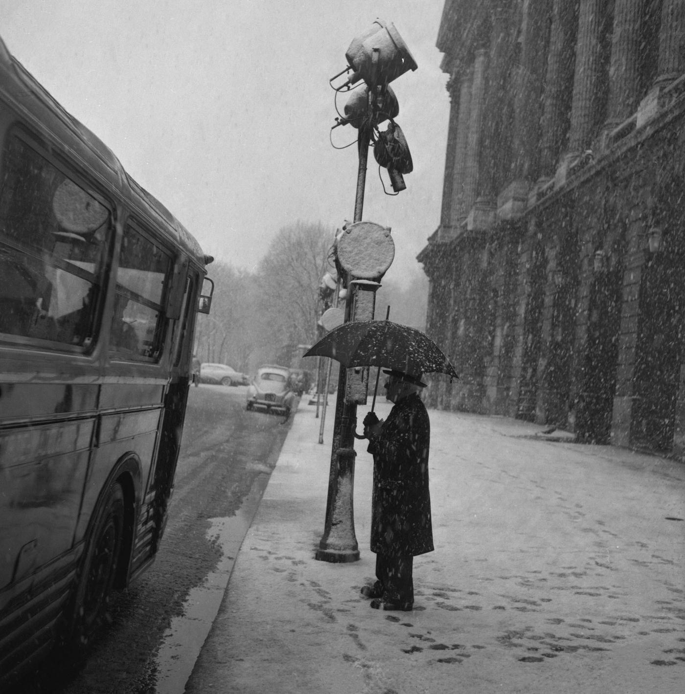 Man Waiting Under Snow At Bus Stop, Paris, February 22, 1957.