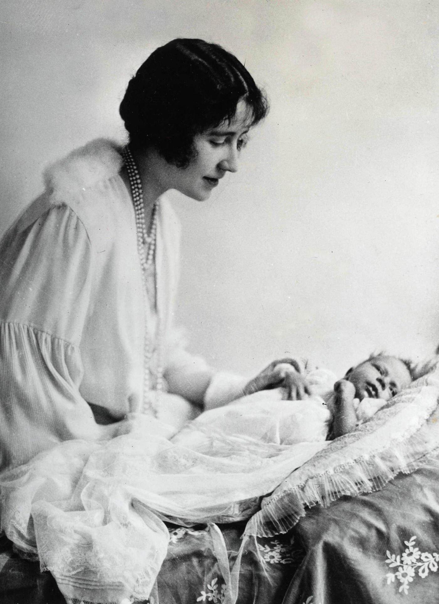 Queen Elizabeth II as a baby of one month old, watched by her mother Queen Elizabeth, then the Duchess of York, May 1926.