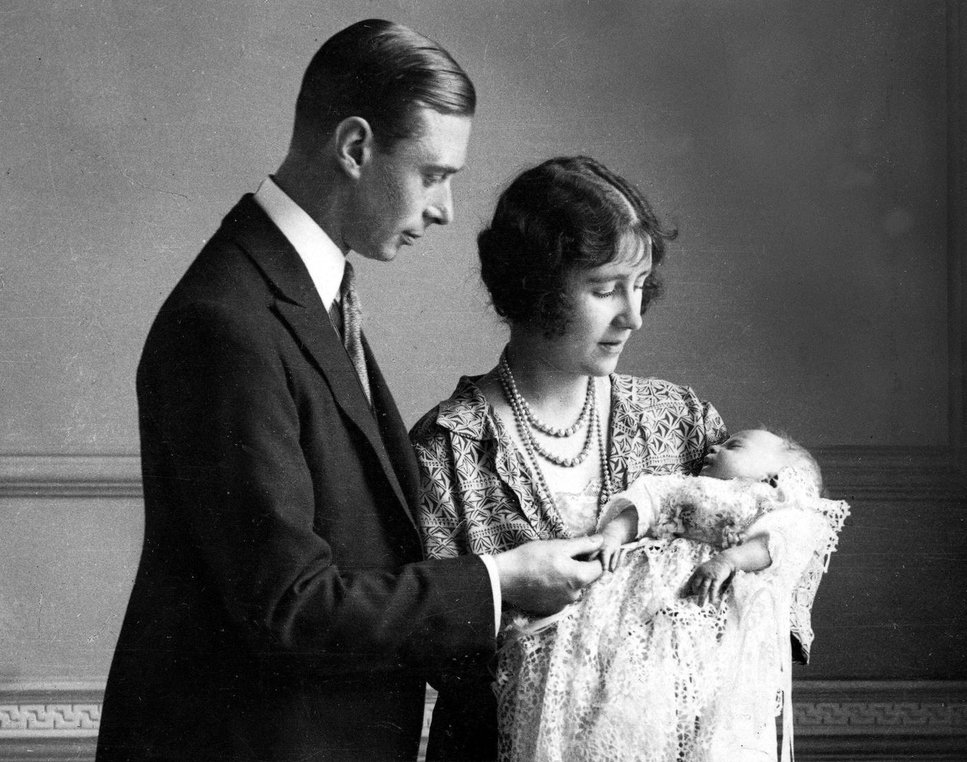 The Duke and Duchess of York with their daughter (later, Queen Elizabeth II) as she sleeps in a precious christening robe, which has been used in the Royal Family for generations, 1926.