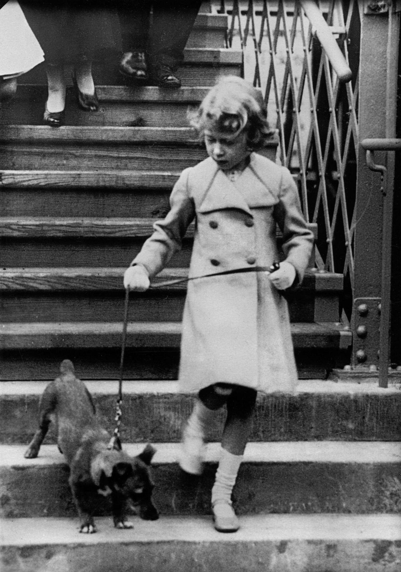 Princess Elizabeth of England takes her dog for a walk, around 1931.