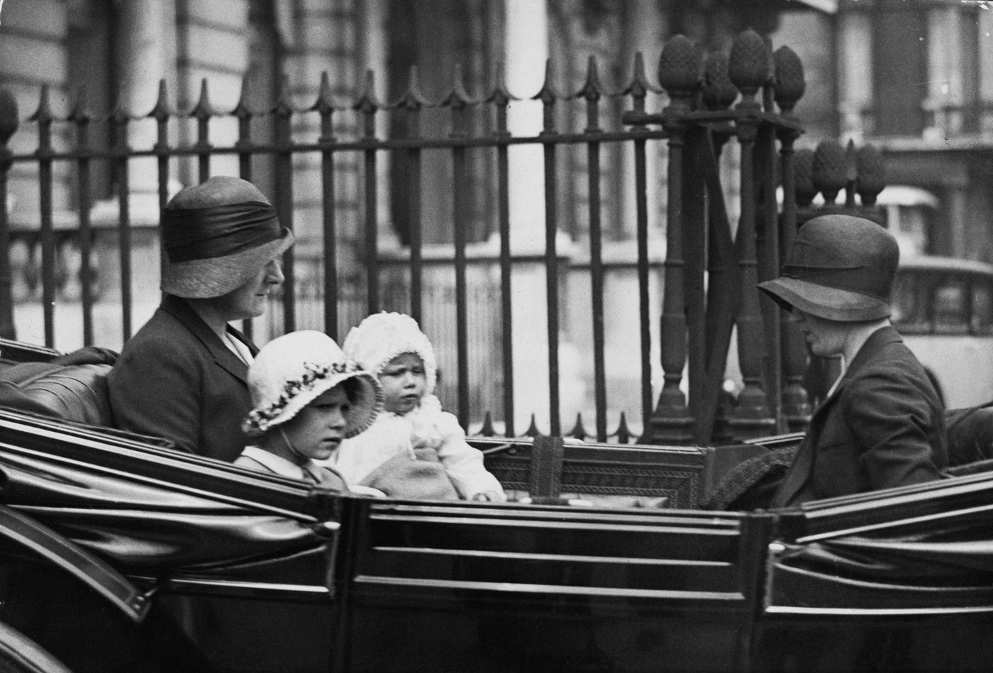 Princess Elizabeth and Princess Margaret ride with their nanny, possibly Clara Knight, for a drive in a carriage from their house in Piccadilly, London on 22nd July 1931.