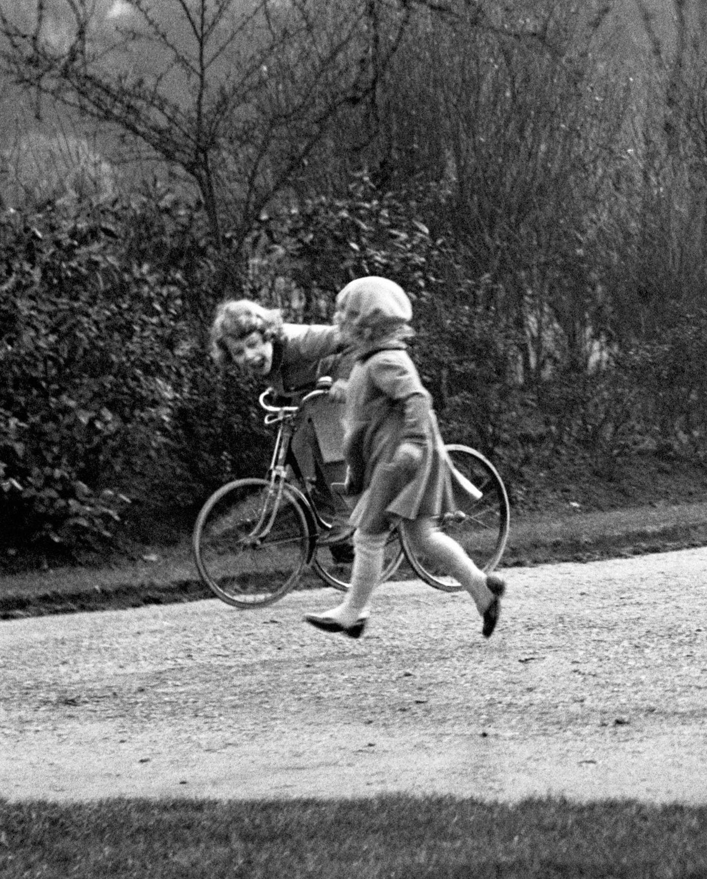 Princess Elizabeth (later Queen Elizabeth II) is pictured on a tricycle in the park in this royalty photo.