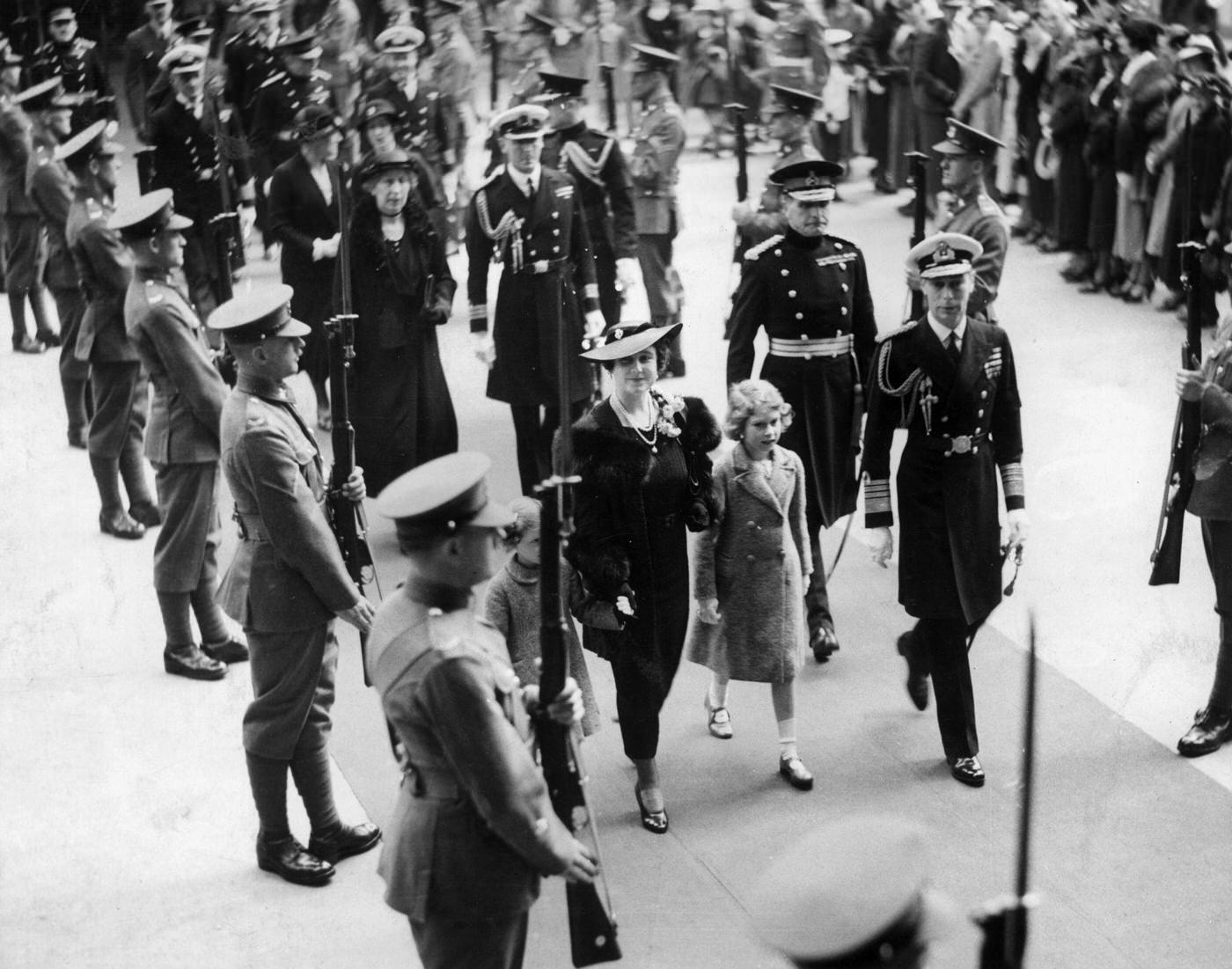 The Duke and Duchess of York and their daughters pass through a Guard of Honour on their way to Olympia in London, November 1935.