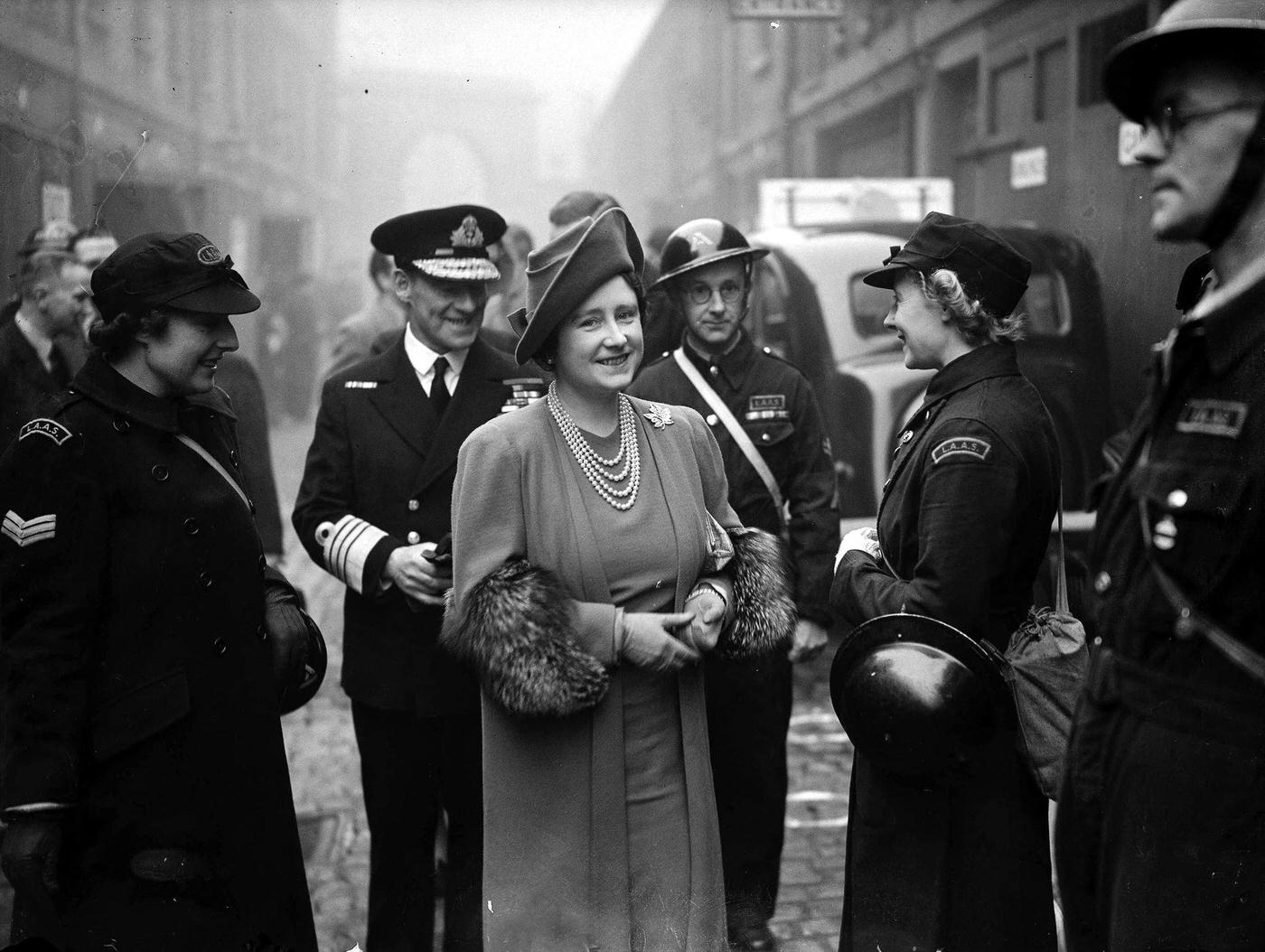 Queen Elizabeth chatting with a woman ambulance driver during her tour of inspection of Ambulance Air Raid Precautions (ARP) depots in London during the Blitz, London, 1940