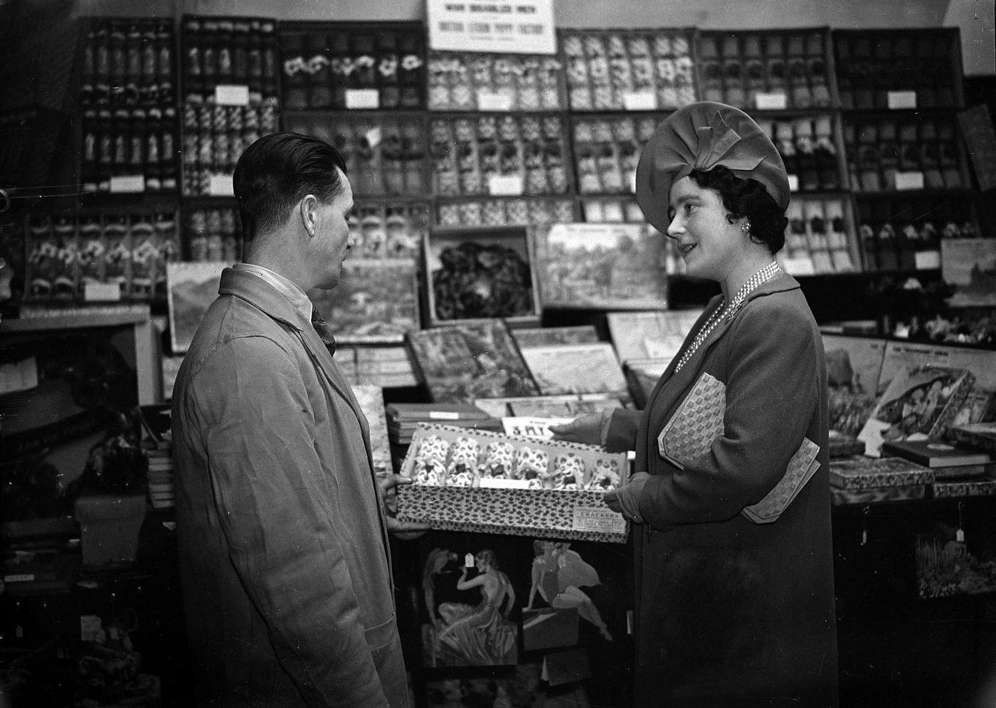 Queen Elizabeth chatting with an employee at a Christmas cracker factory during a wartime morale-boosting visit.