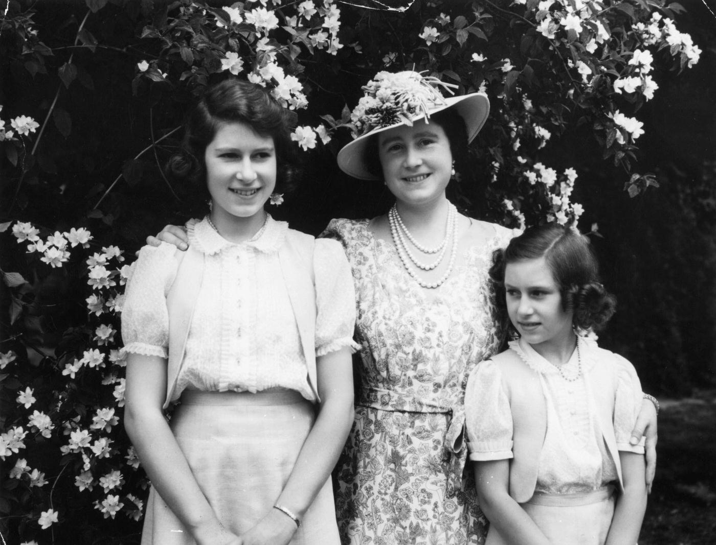 Queen Elizabeth with her daughter Princess Elizabeth (later Queen Elizabeth II) and Princess Margaret in the garden at Windsor Castle during WW II.