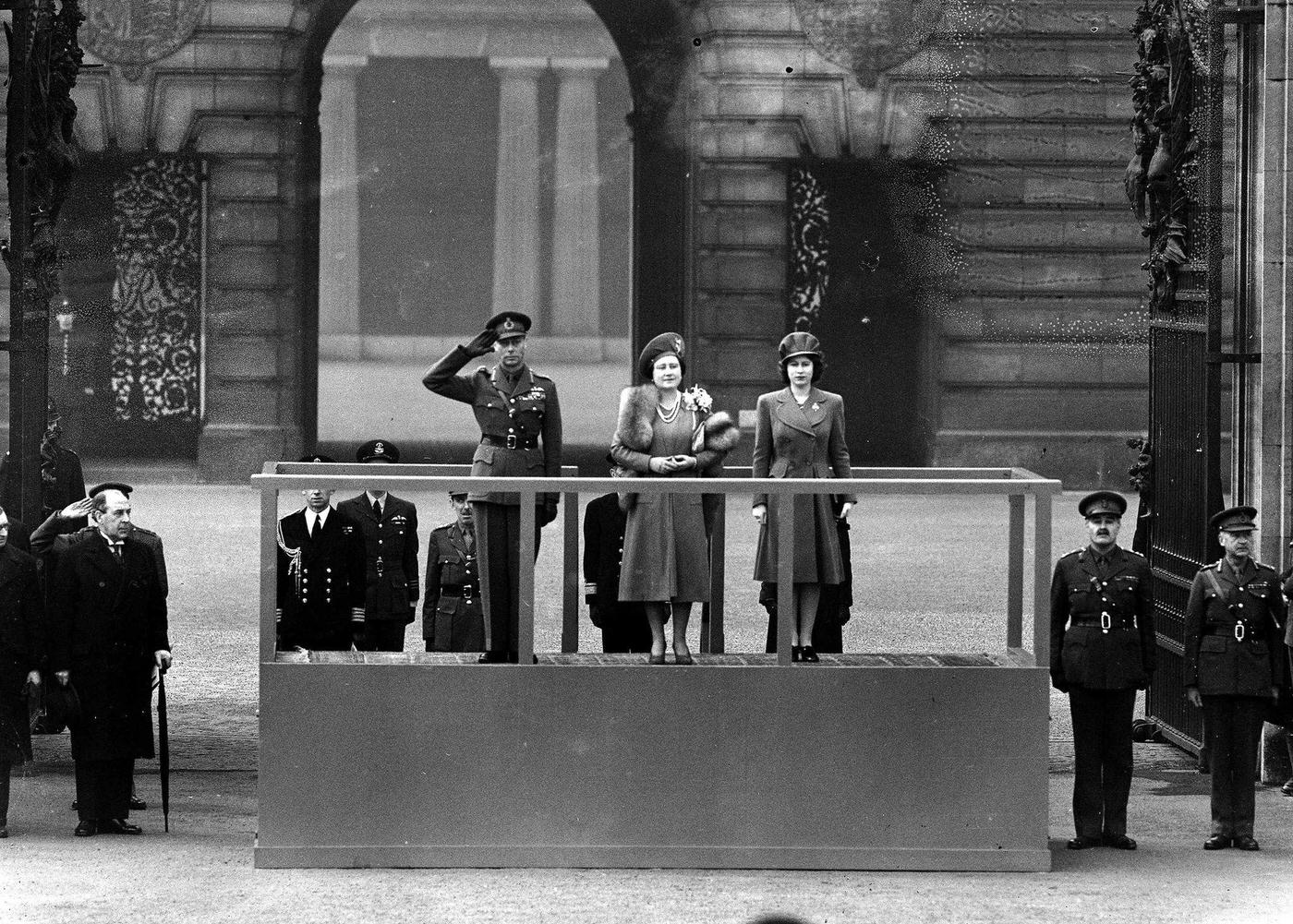 King George VI and Queen Elizabeth accompanied by Princess Elizabeth on the saluting base at Buckingham Palace, as the "Salute the Soldier" parade marches by.