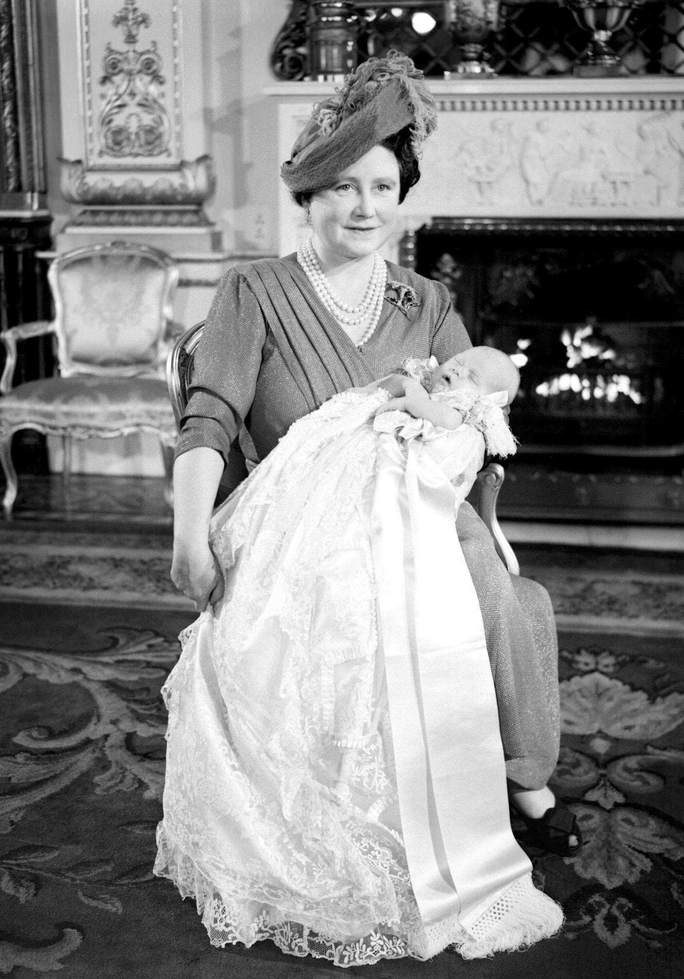 Queen Mother holding her first grandchild Prince Charles at his christening at Buckingham Palace, 1950.