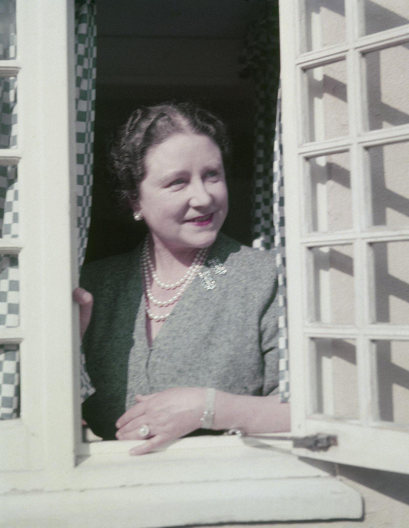 The Queen Mother at a window in the little Welsh house at the Royal Lodge in Windsor in England, 1954.