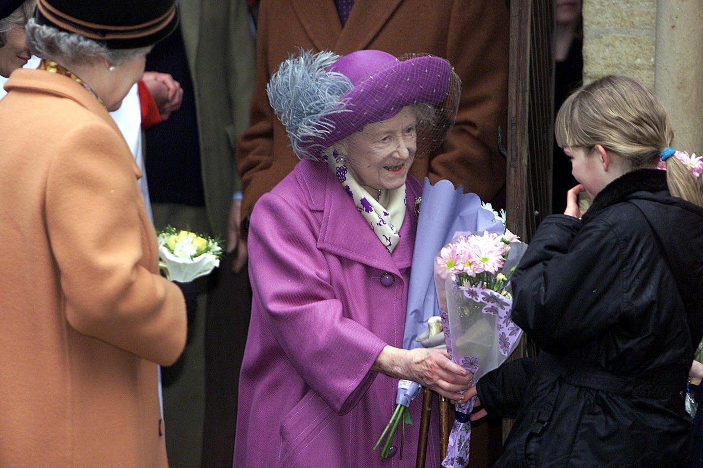 The Queen Mother accepts flowers from a young girl as she attends a church service commemorating the death 100 years ago of Queen Victoria, 2001.