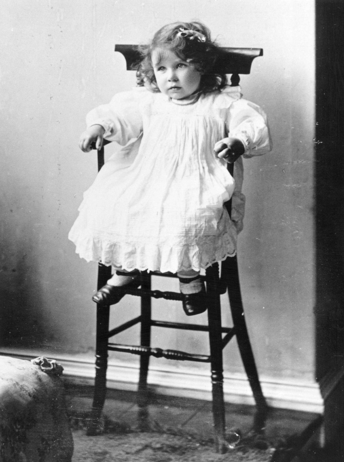 Lady Elizabeth Bowes-Lyon, future Queen Consort to King George VI sitting in a high chair on her second birthday, 1902.