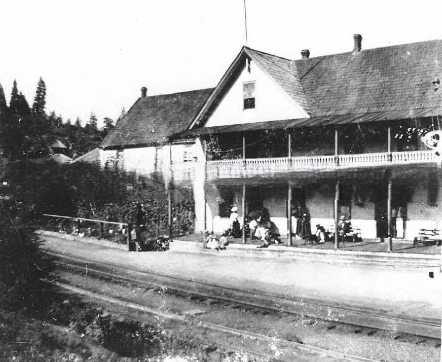 Building next to railroad tracks, 1890