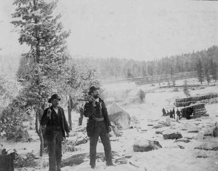 Two armed men at winter camp, 1890