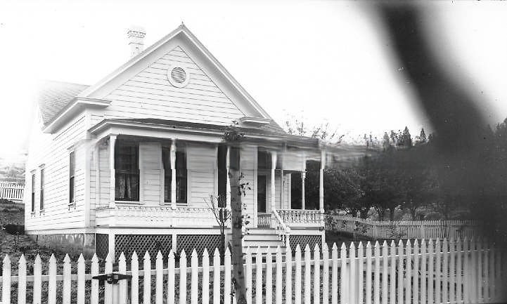 Small Victorian-styled house with white picket fence, 1895