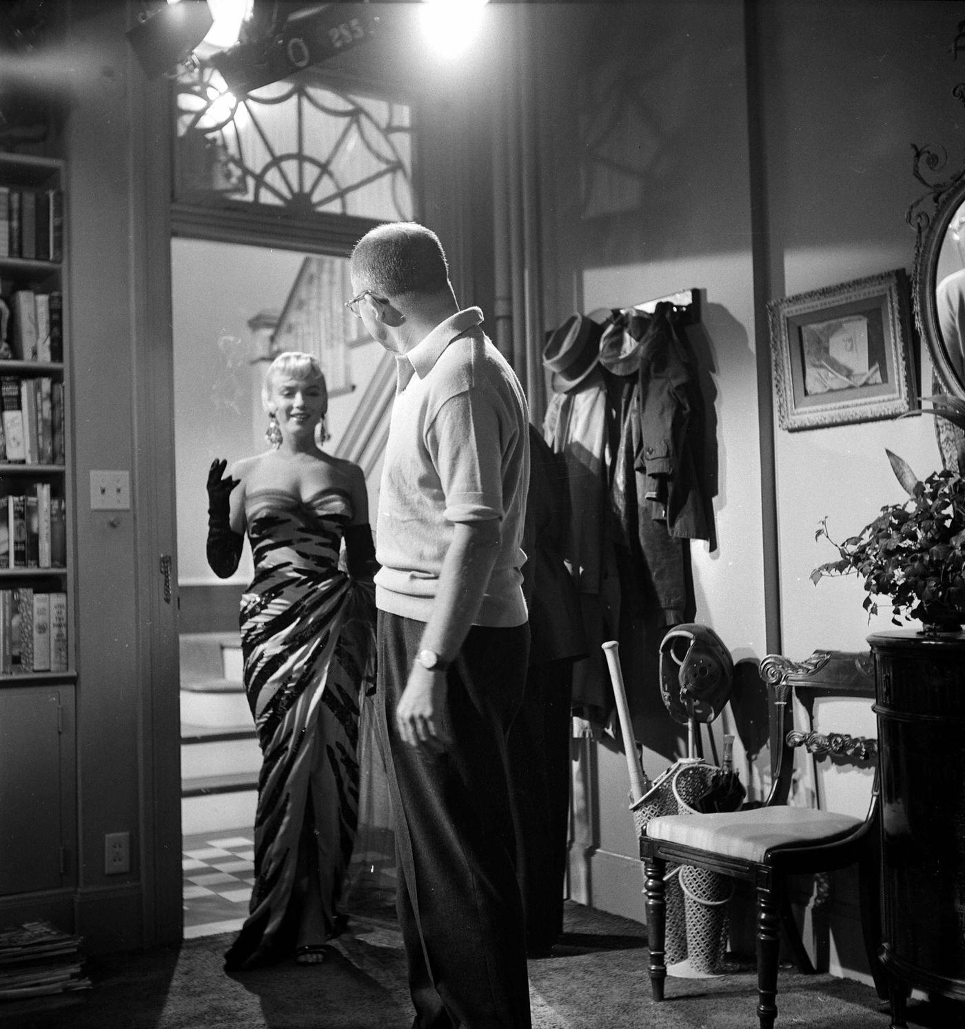 Monroe stands in a doorway wearing a tiger-striped dress on set with director Billy Wilder in 1954 during the filming of "The Seven Year Itch"