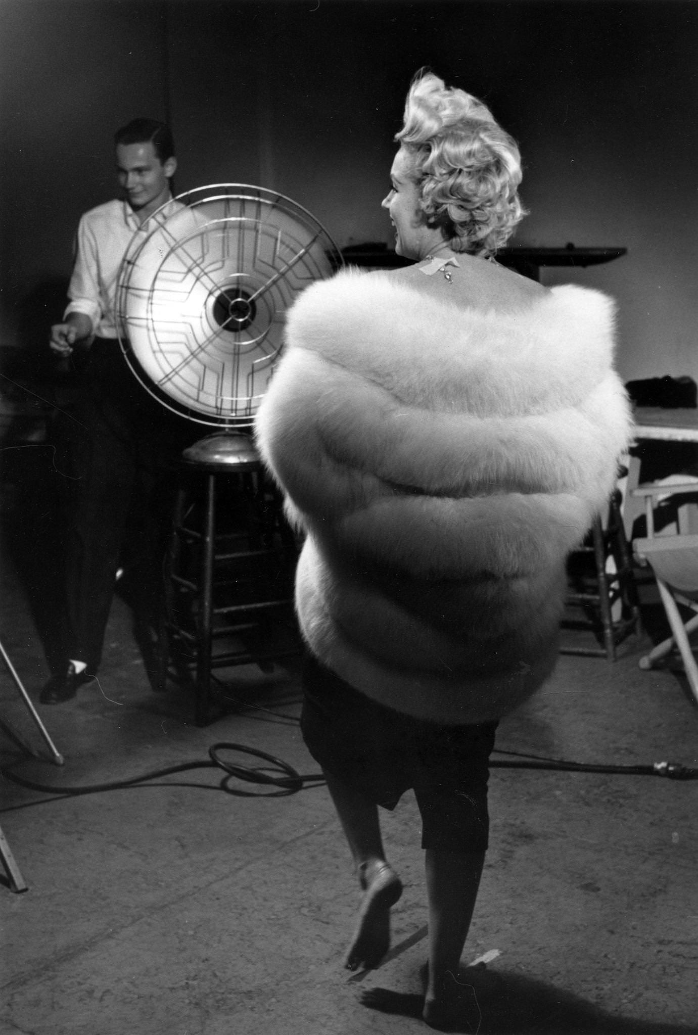 Marilyn Monroe wearing a white stole fur wrap prepares for a publicity photo shoot with Richard Avedon in his studio in 1954 during the filming of "The Seven Year Itch" in New York