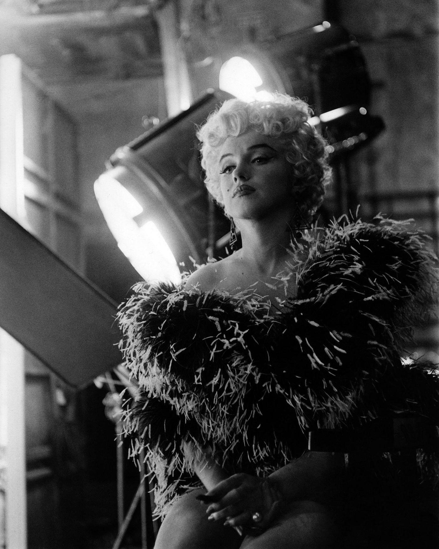 Marilyn Monroe wearing a feather boa in front of film set lights in 1954 during the filming of "The Seven Year Itch" in Los Angeles