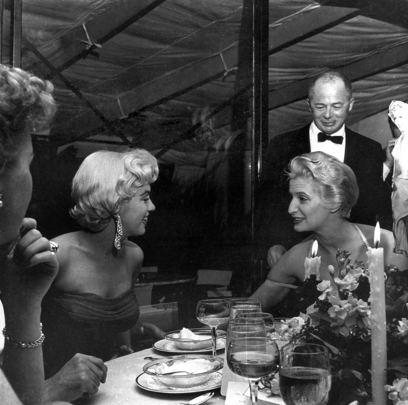 Marilyn Monroe with director Billy Wilder and Joan Axelrod, the playwright George Axelrod's wife, at the wrap party for the filming of "The Seven Year Itch" at Romanoff's Restaurant
