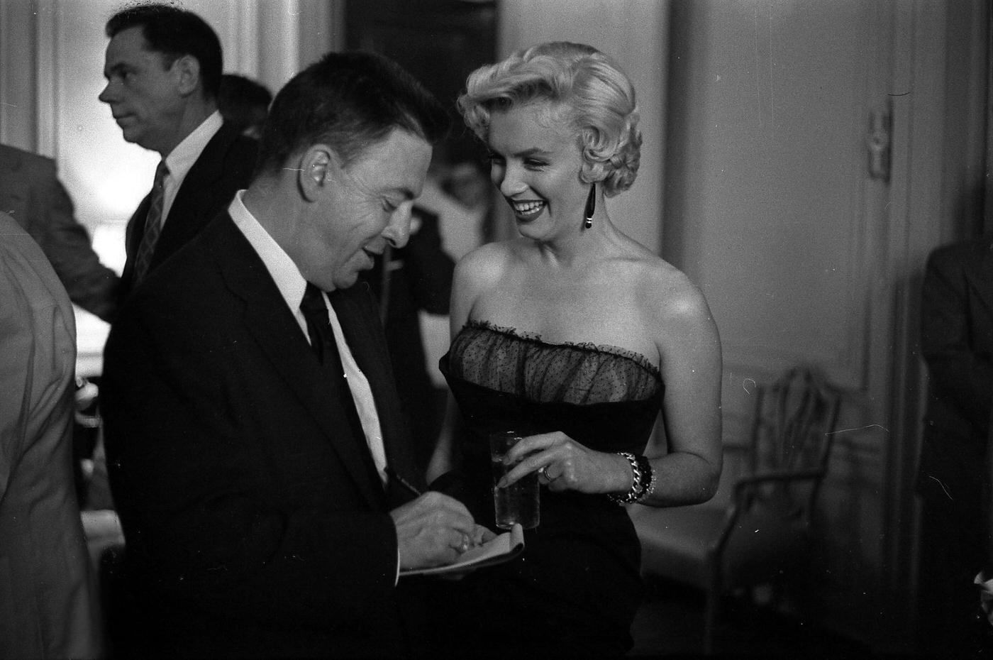 Marilyn Monroe with co-star Tom Ewell and newspaper columnist Earl Wilson at a press party for "The Seven Year Itch" in 1954 in New York