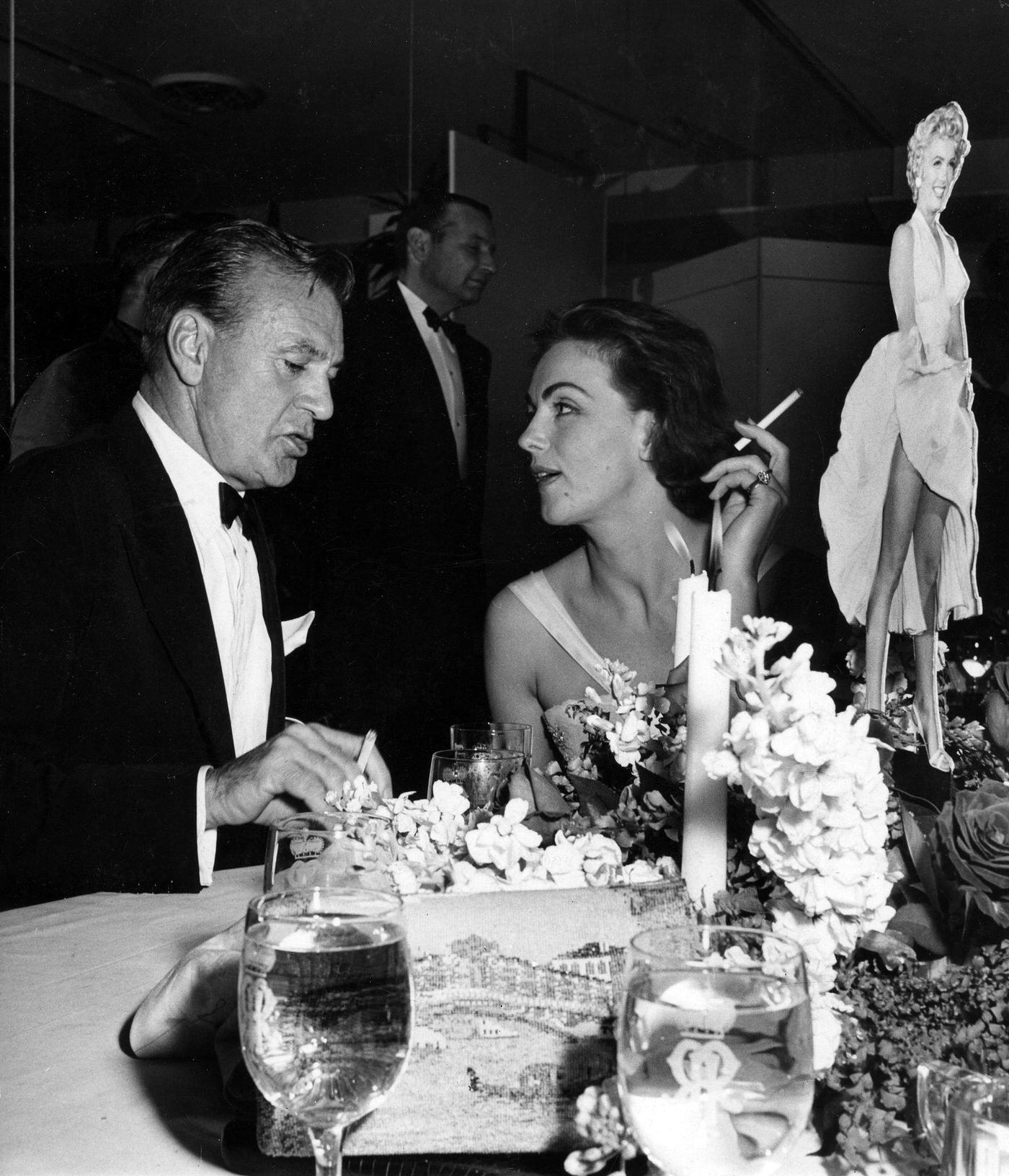Gary Cooper with Hjordis Tersmeden, wife of actor David Niven, at the wrap party for the filming of "The Seven Year Itch" at Romanoff's Restaurant in 1954