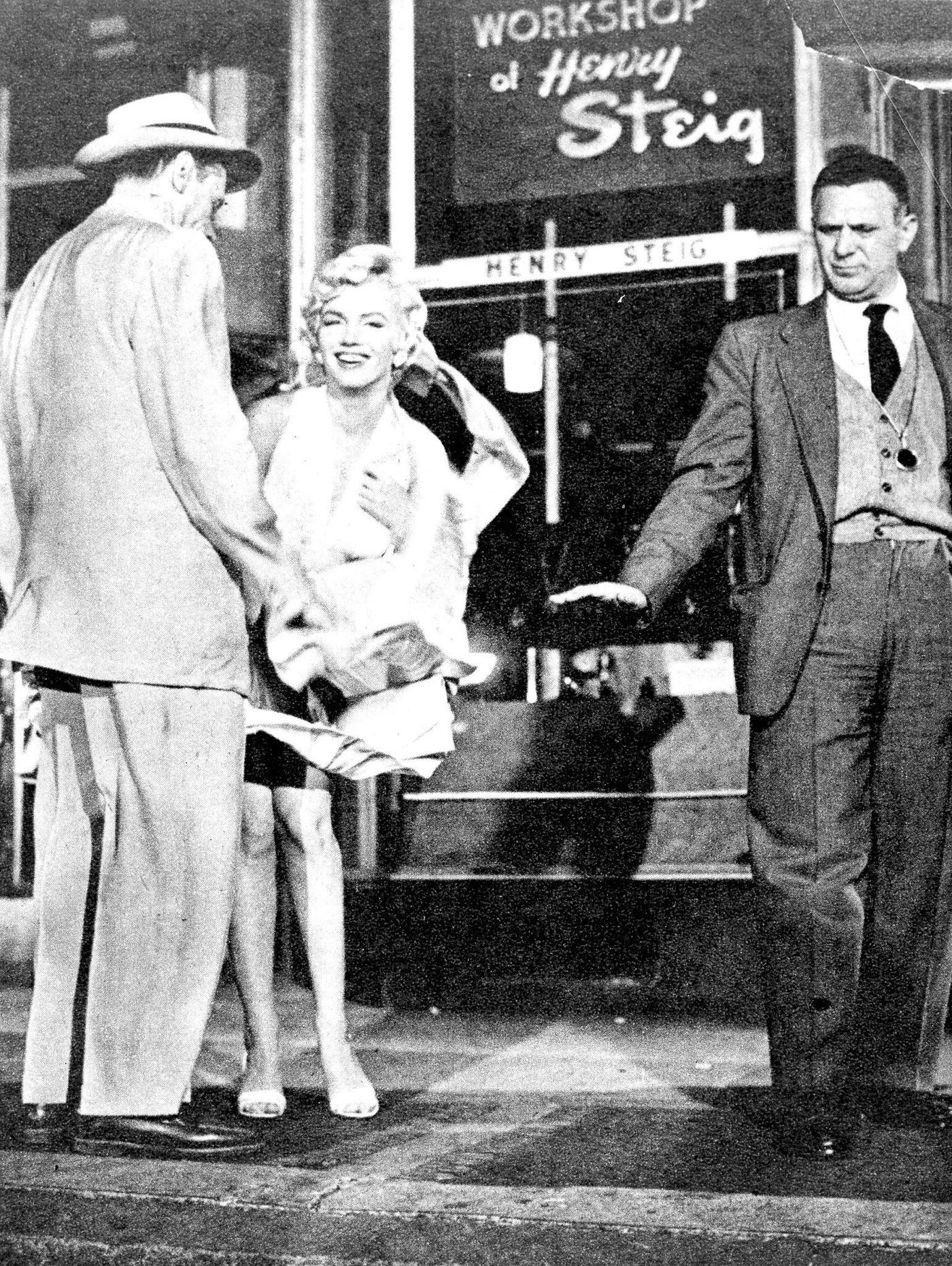 Marilyn Monroe with the skirt of her white dress blowing as she stands over a subway grate at the corner of 51st Street and Lexington Avenue with co-star Tom Ewell and cinematographer Milton Krasner in September, 1954