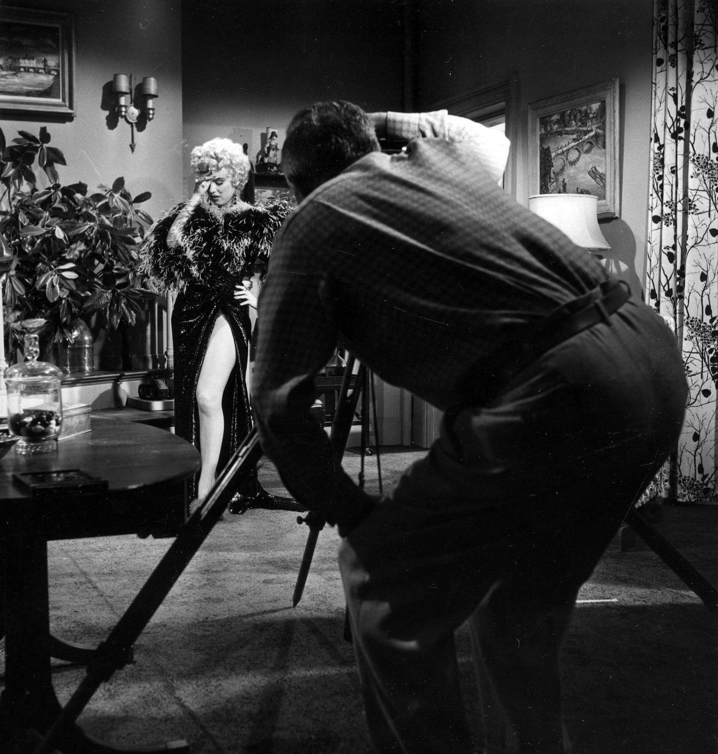 Marilyn Monroe in front of a camera wearing a feather boa during the filming of "The Seven Year Itch" in 1954