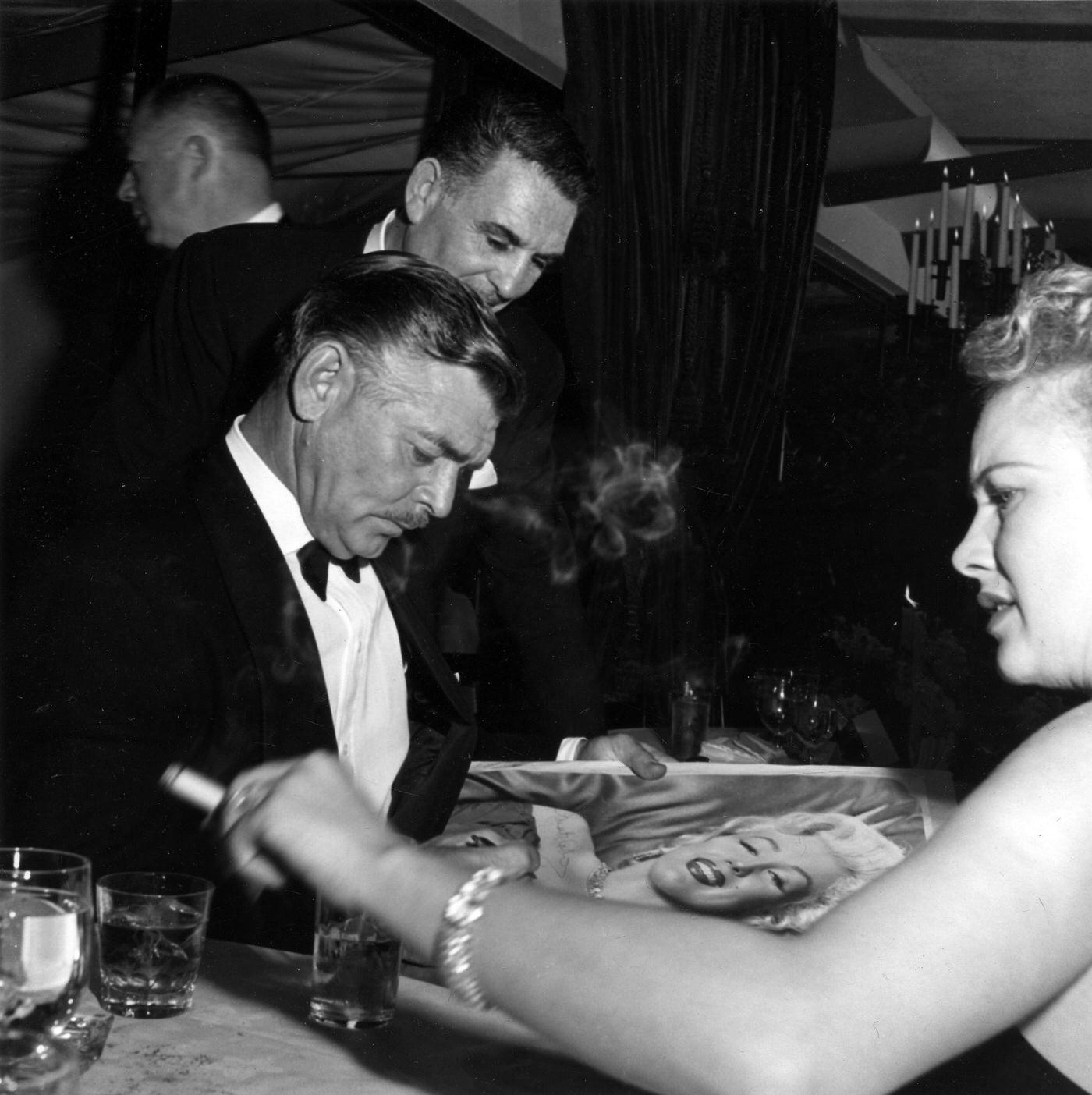 Clark Gable, Charles K Feldman, and Jean Howard at the wrap party for the filming of "The Seven Year Itch" at Romanoff's Restaurant