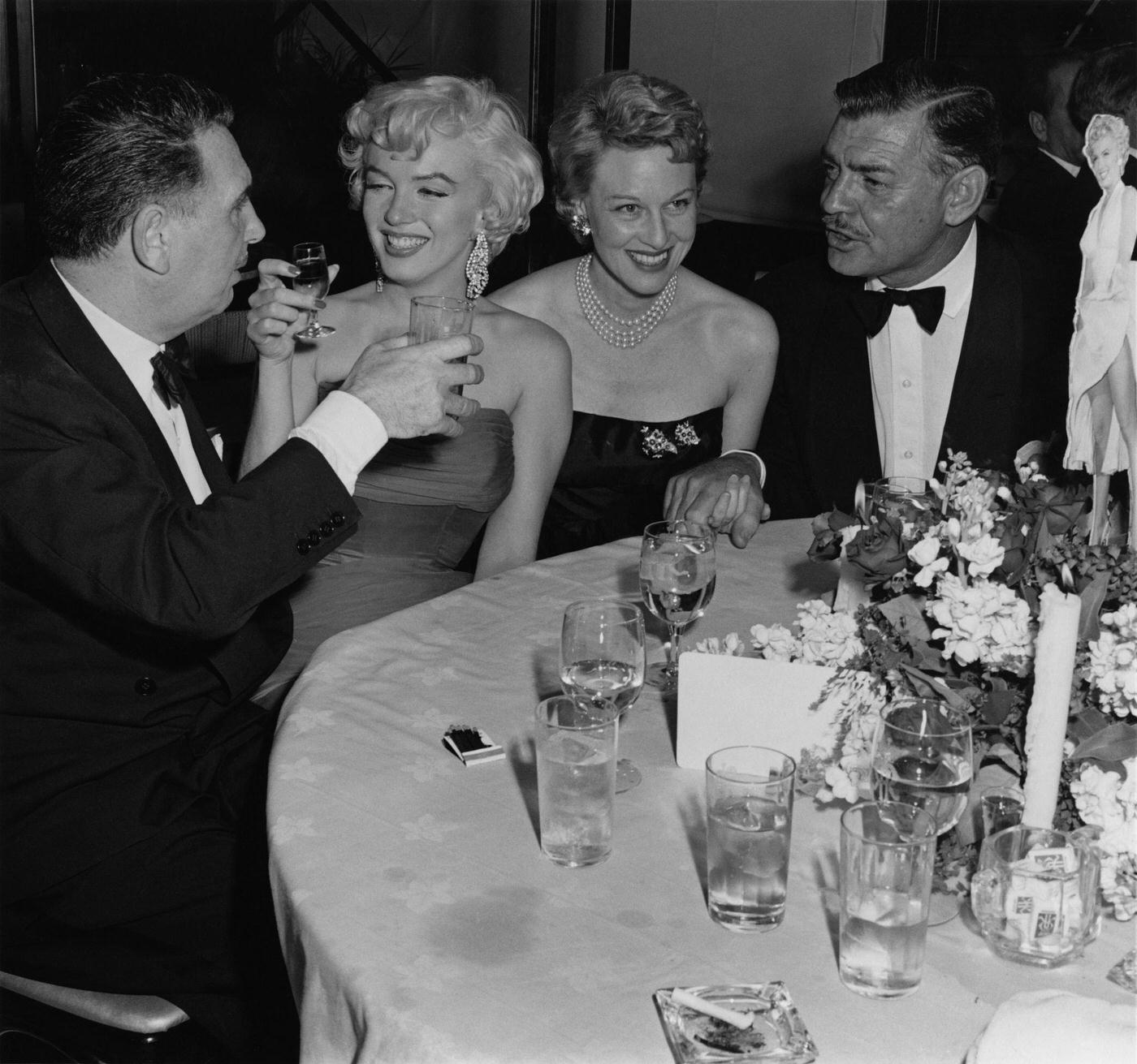 Marilyn Monroe with actor Clark Gable, producer Charles K Feldman and actress Jean Howard at the wrap party for the filming of "The Seven Year Itch"