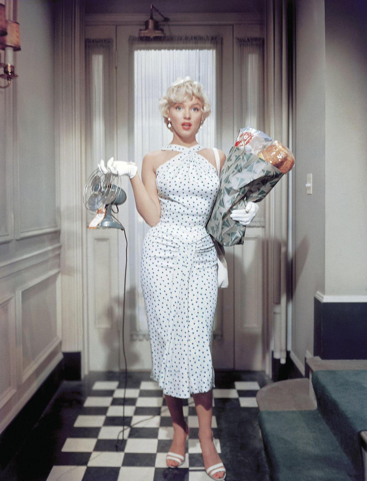 Marilyn Monroe leaning out of a window wearing a bathrobe in 1954 during the filming of "The Seven Year Itch"