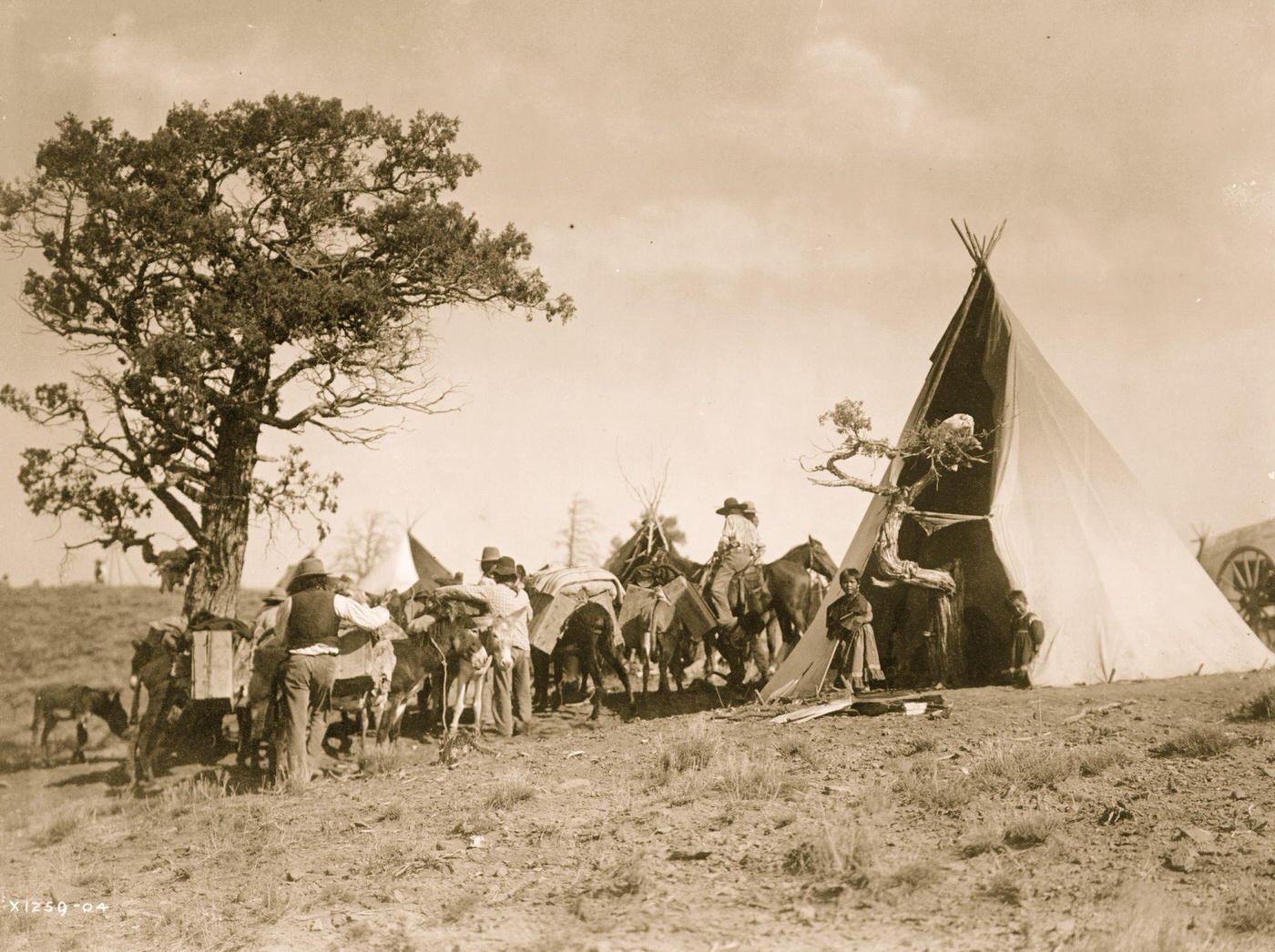 Men and pack animals gathered outside Jicarilla tipi., 1905
