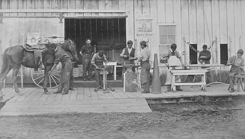 This photograph from 1882 shows a class in blacksmithing at the Forest Grove School in Oregon.