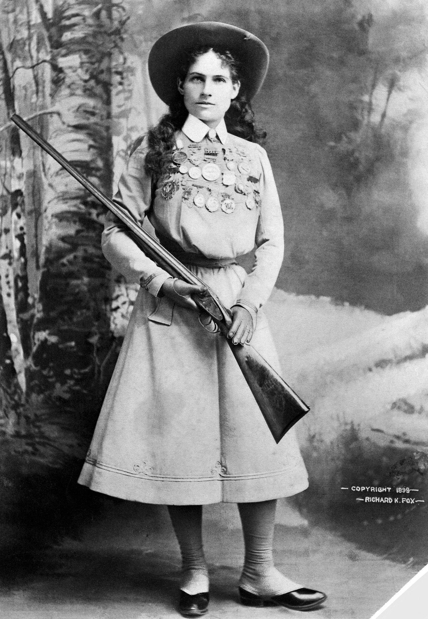Target shooter Annie Oakley, star of Buffalo Bill's Wild West show, is shown holding a rifle.