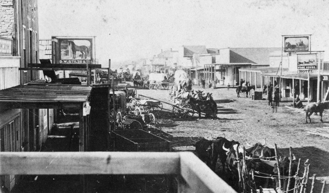Western Town, wagons arriving in a new town in the American west, circa 1870.