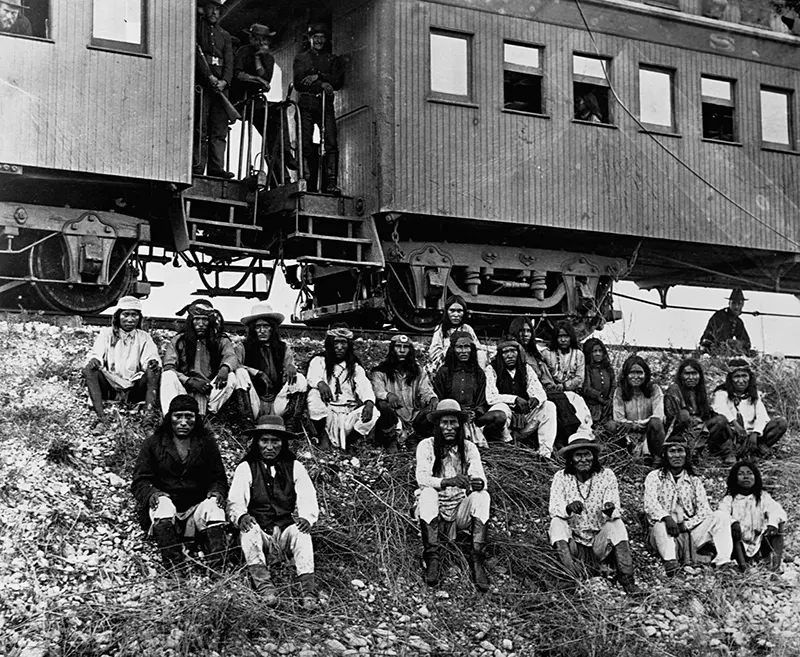 A band of Apache Indian prisoners take a rest stop beside Southern Pacific Railway near Nueces River, Texas in 1886.