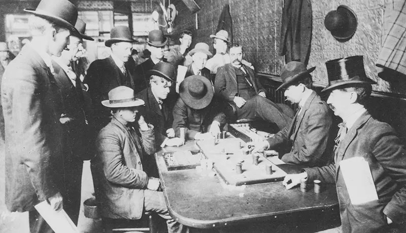 Men gather to gamble over a game of Faro inside a saloon in Bisbee, Arizona in 1900.