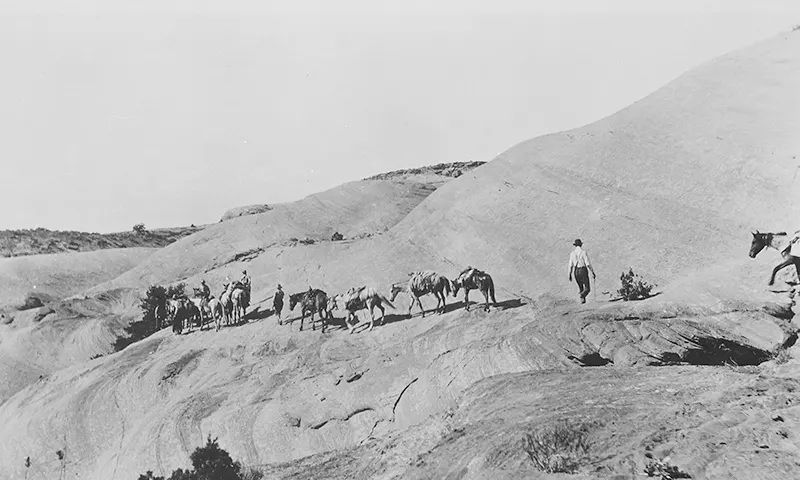 Discovery party and horses on hot, slick rocks of Navajo Mountain on their way to Rainbow Bridge in Utah in 1909.