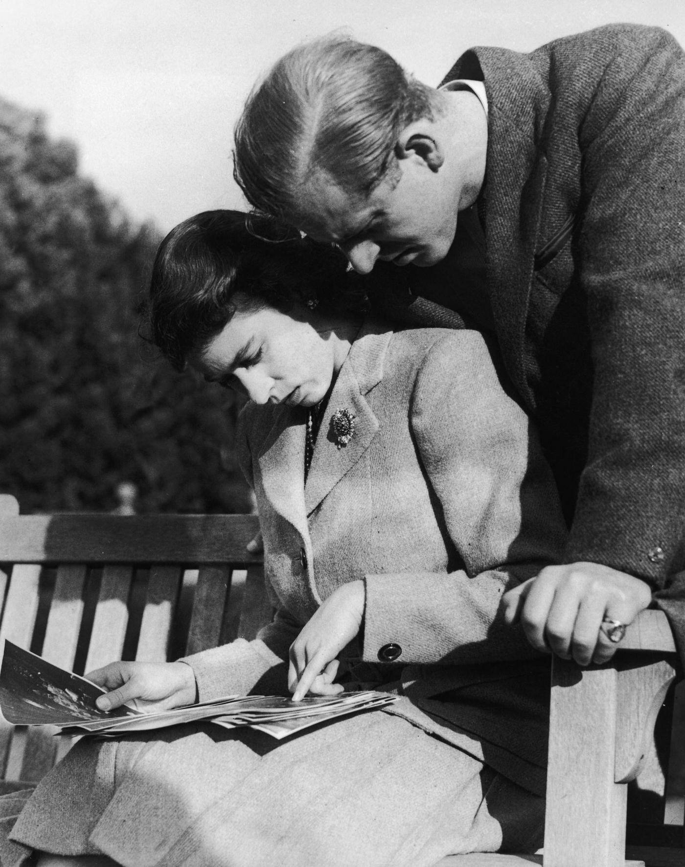 Princess Elizabeth and Philip Mountbatten studying their wedding photographs while on honeymoon in Romsey, Hampshire, November 1947.