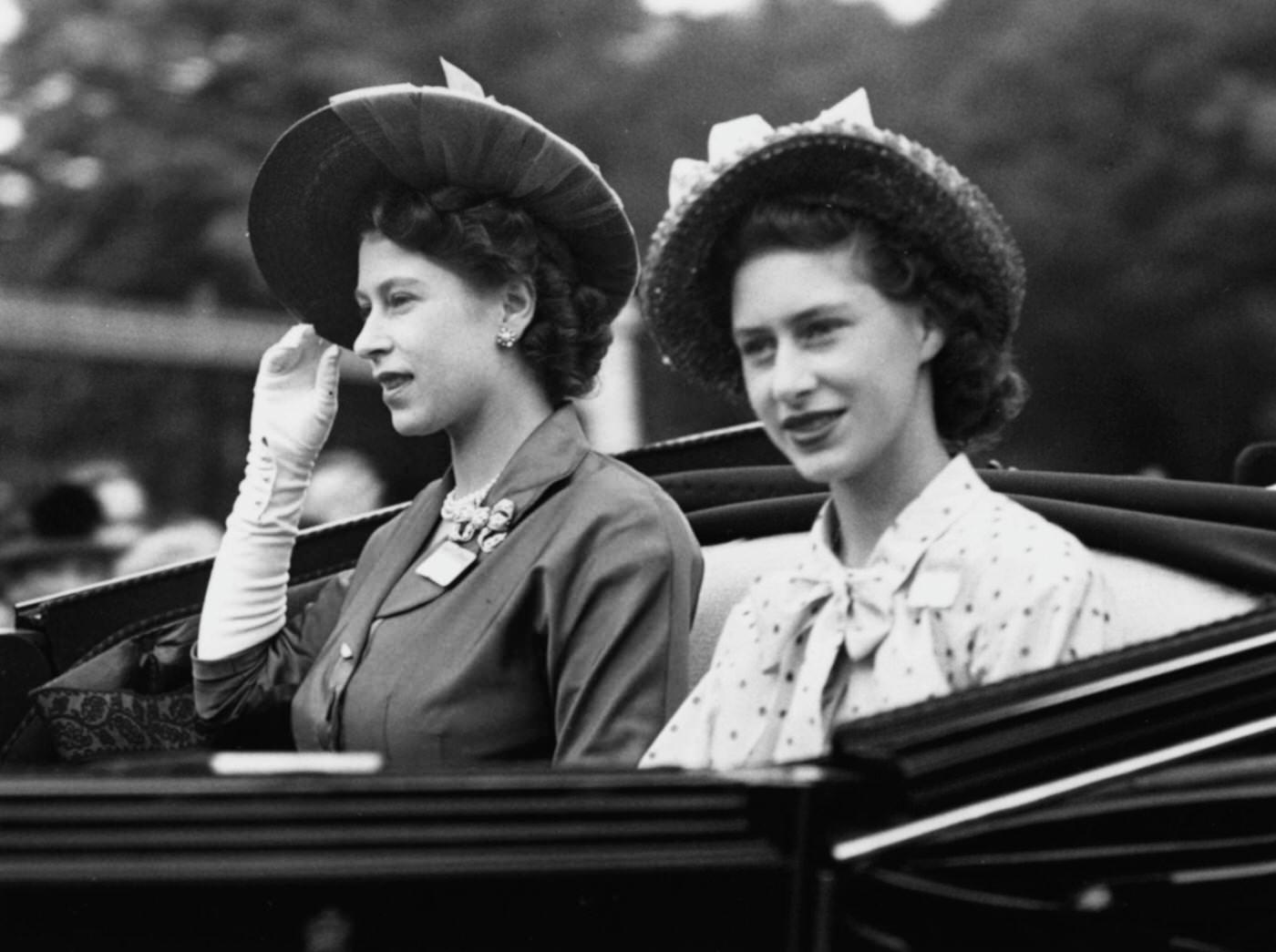 Princesses Elizabeth and Margaret drive in an open carriage to the Royal box at Ascot Racecourse to watch the running of the Gold Cup race, England, 17 June 1948.