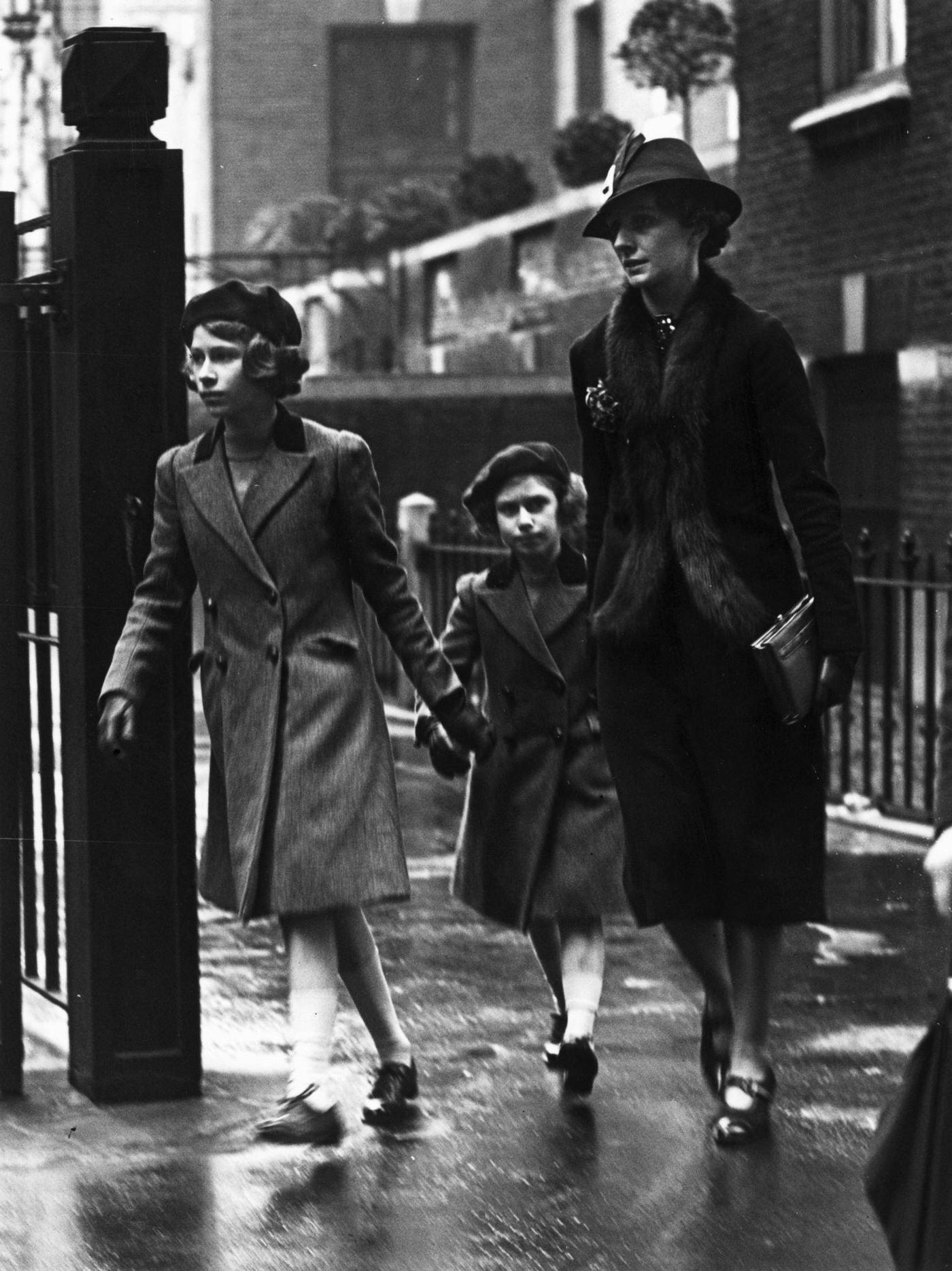 Royalty and Nanny: Princess Elizabeth and her sister Princess Margaret with their nanny Miss Marion Crawford leaving the headquarters of the YWCA (Young Women's Christian Association) in London, 15th May 1939.